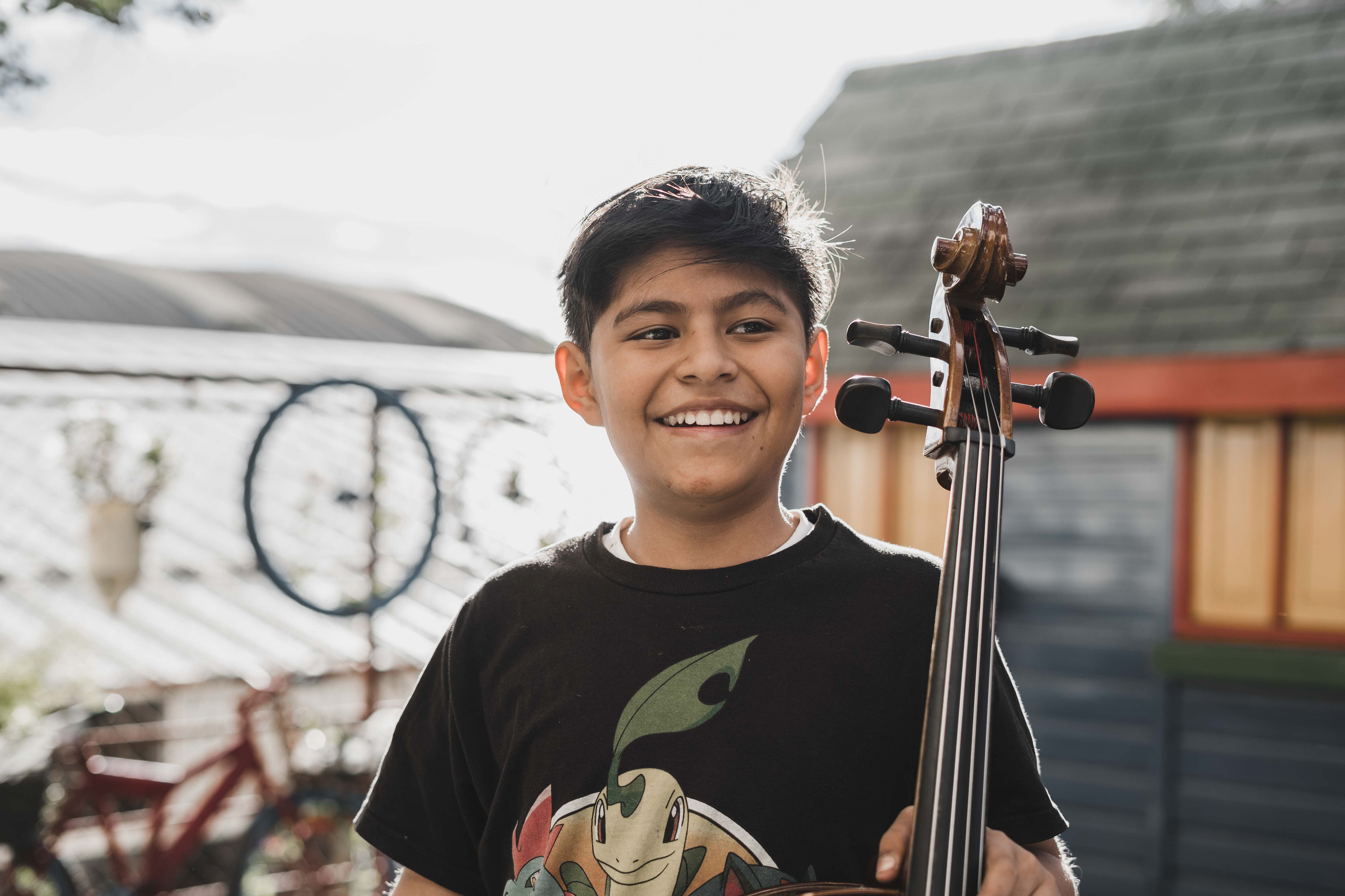 A young cellist smiling at an In Concert program