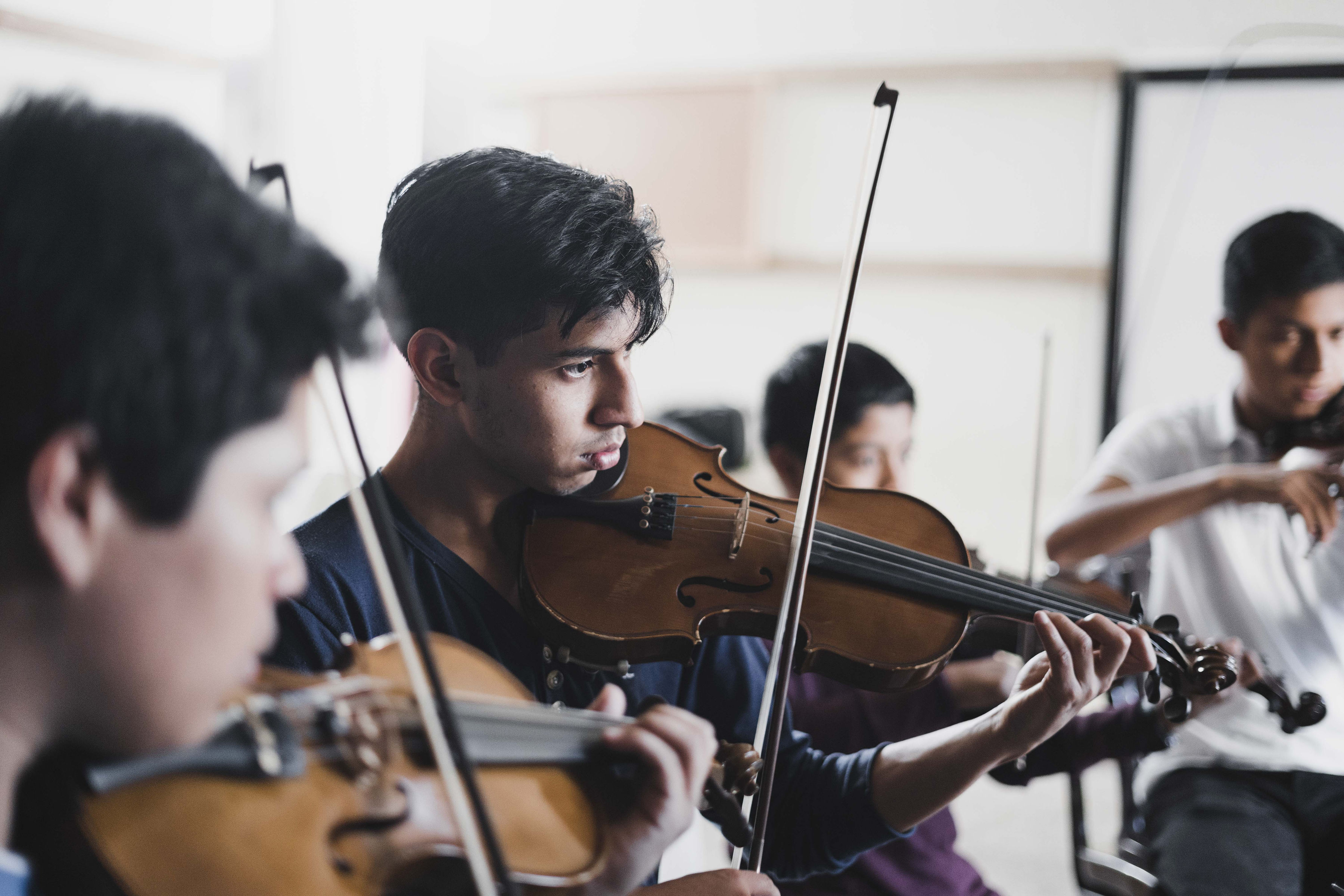 Students playing violins together
